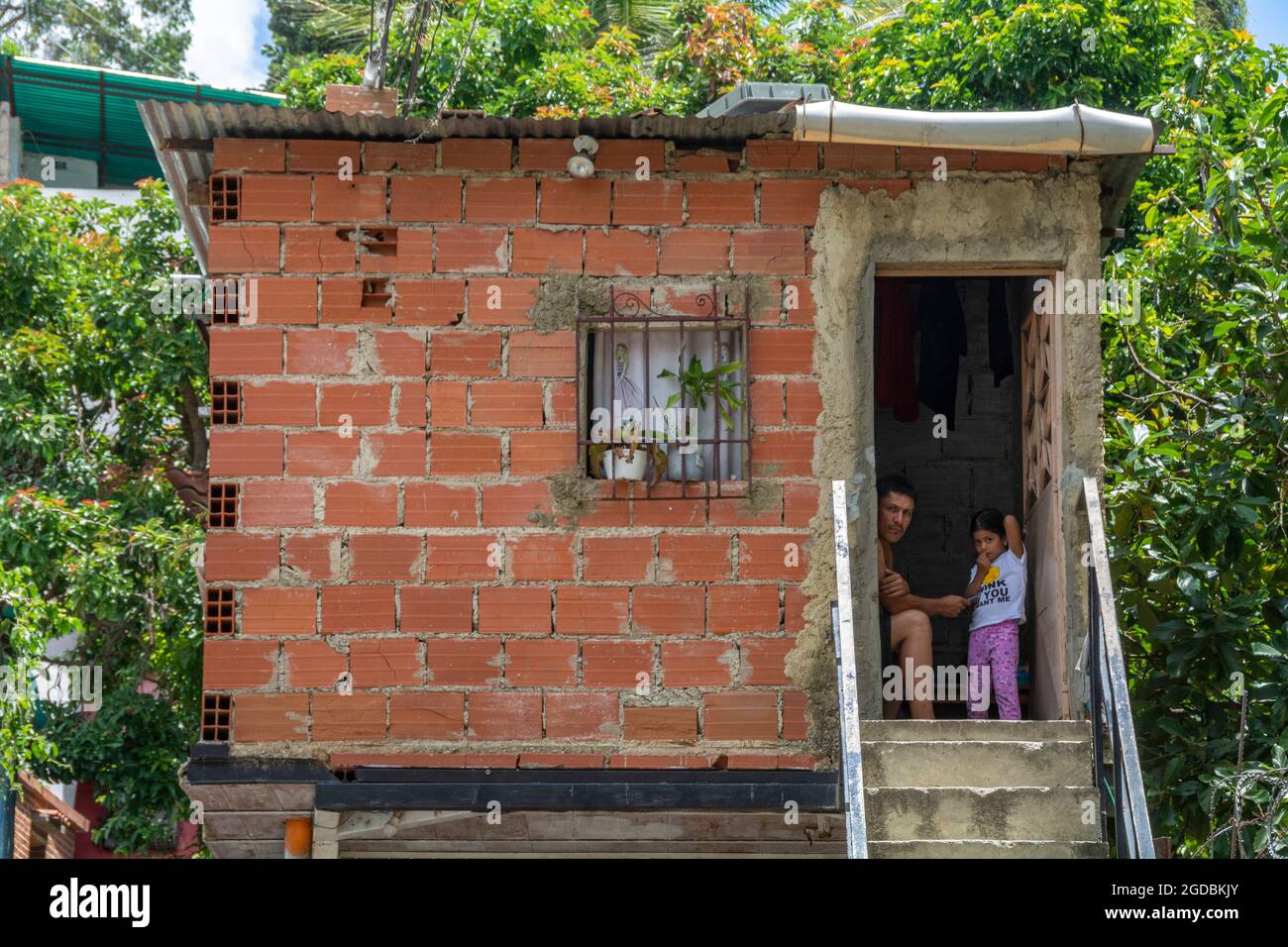 A man and his daughter in a humble house in the Las Mayas neighborhood in Caracas, Venezuela. Stock Photo