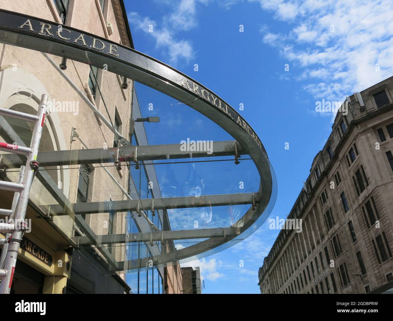 Argyle Street shoppers are reflected in the glass roof that's at the entrance to the Argyll Arcade, Glasgow's Jewellery Quarter in a covered walkway. Stock Photo