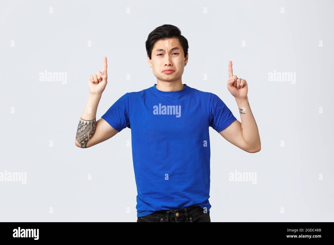 Different emotions, people lifestyle and advertising concept. Desperate and sad young grieving asian man in blue t-shirt, sobbing and whining Stock Photo