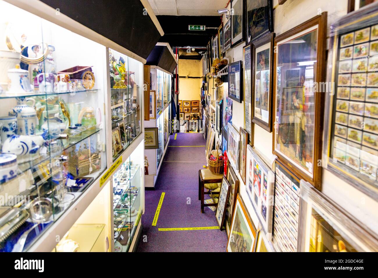 Antique display cabinets and framed pictures at Herts & Essex Antiques Centre, Sawbridgeworth, UK Stock Photo