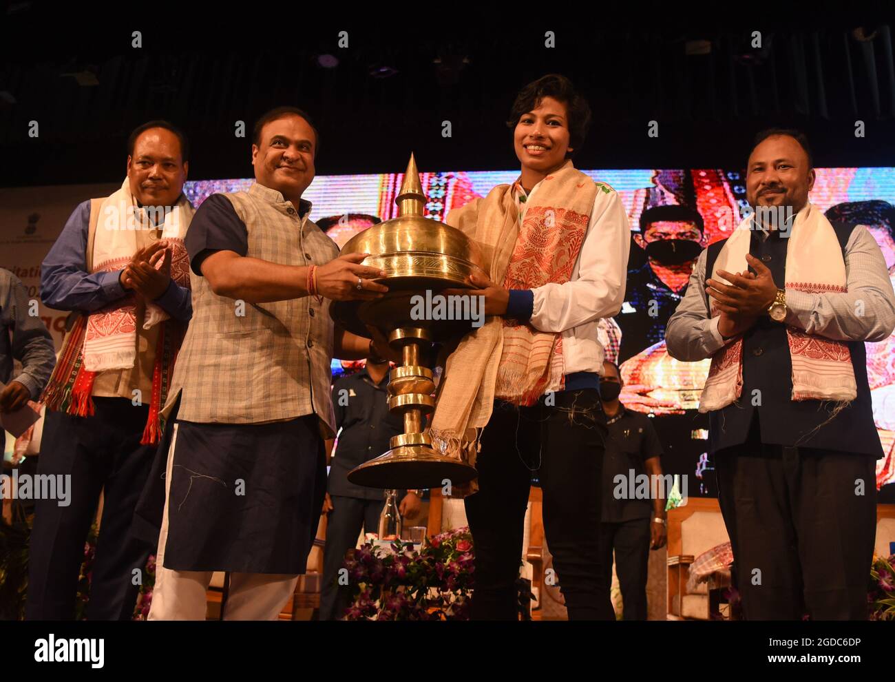 Guwahati, India. August 12, 2021: Assam Chief Minister Dr. Himanta Biswa Sarma felicitate Bronze medalist in Tokyo Olympics, boxer Lovlina Borgohain with a traditional Xarai during a function at Srimanta Sankardev Kalakshetra auditorium on August 12, 2021 in Guwahati, India. Lovlina Borgohain of Assam is a Olympic bronze medalist in Boxing in Tokyo 2020. Credit: David Talukdar/Alamy Live News Stock Photo