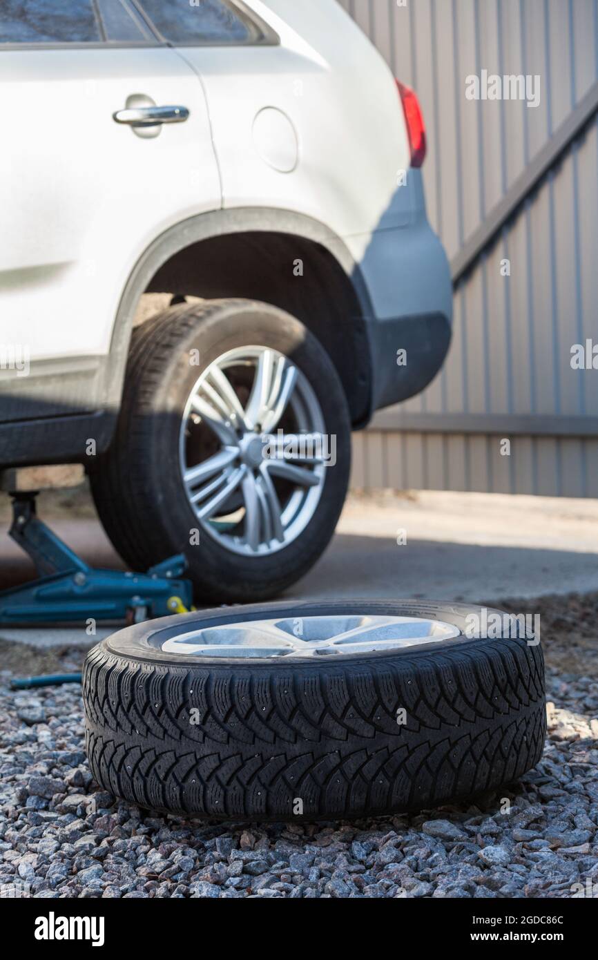 Seasonal winter tyres change. Snow tire lying on ground, is ready to