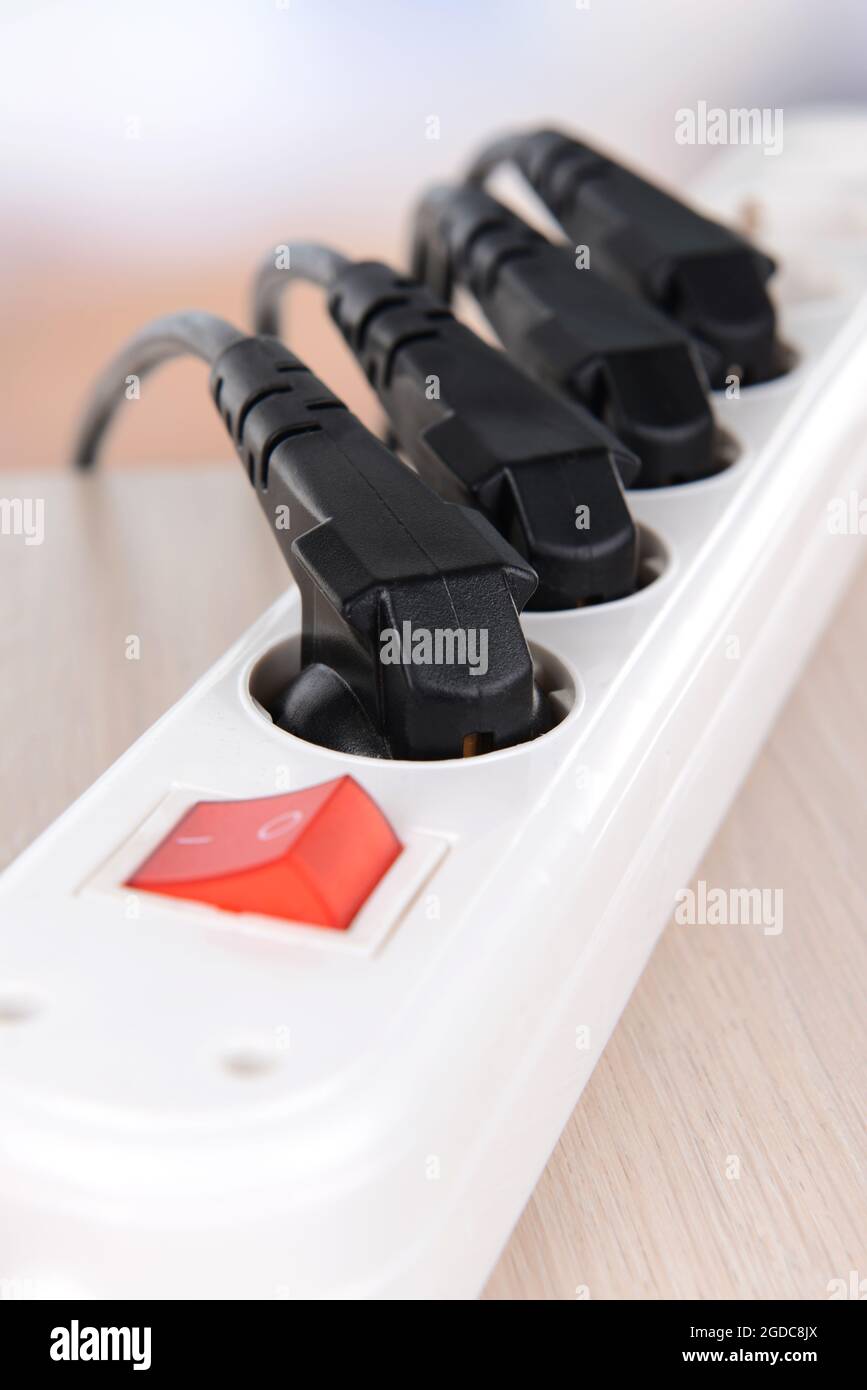 Many plugs plugged into electric power bar closeup Stock Photo Alamy