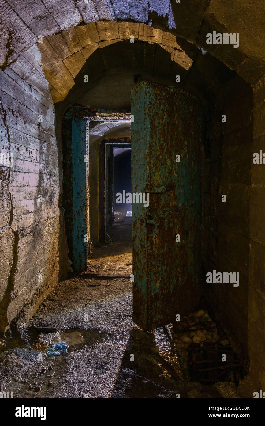 Rusted metal armored door in old abandoned Soviet bunker. Stock Photo