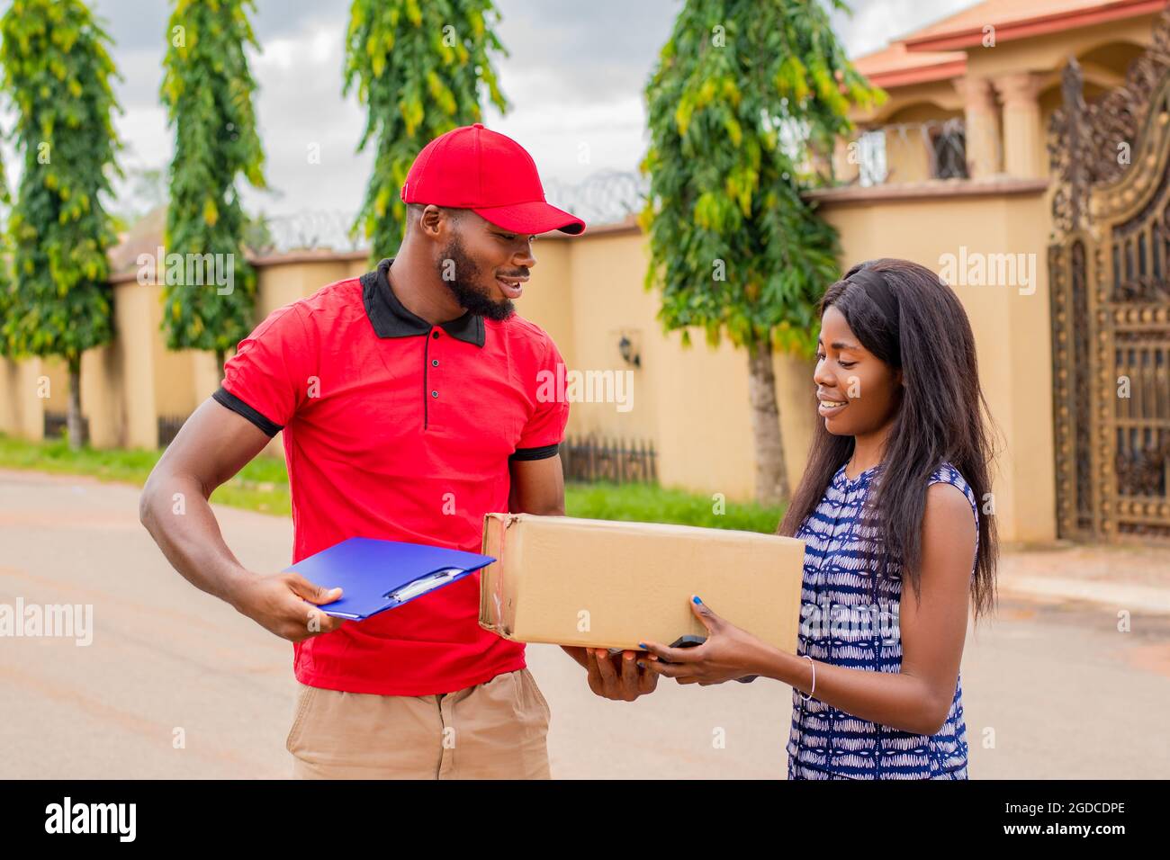 african delivery worker delivers a package to a woman Stock Photo Alamy