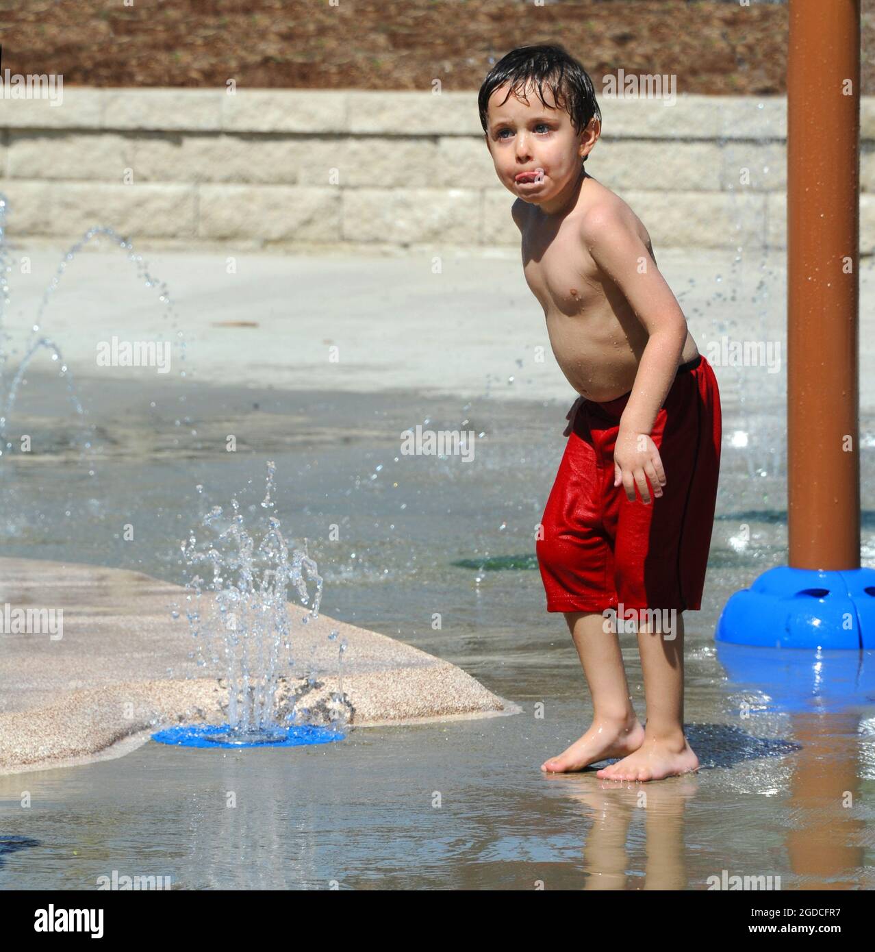 Little boy gets caught with his tongue licking the water from his face