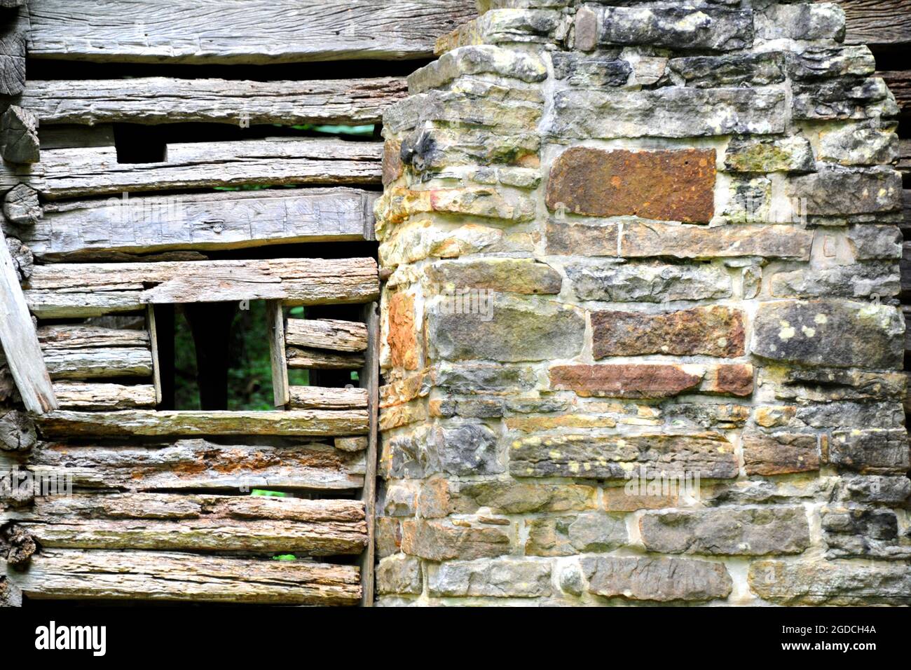 Background image shows wall of the historic Villines Cabin in the historic area of Boxley Valley in Arkansas.  Cabin has hand hewn logs and stone chim Stock Photo