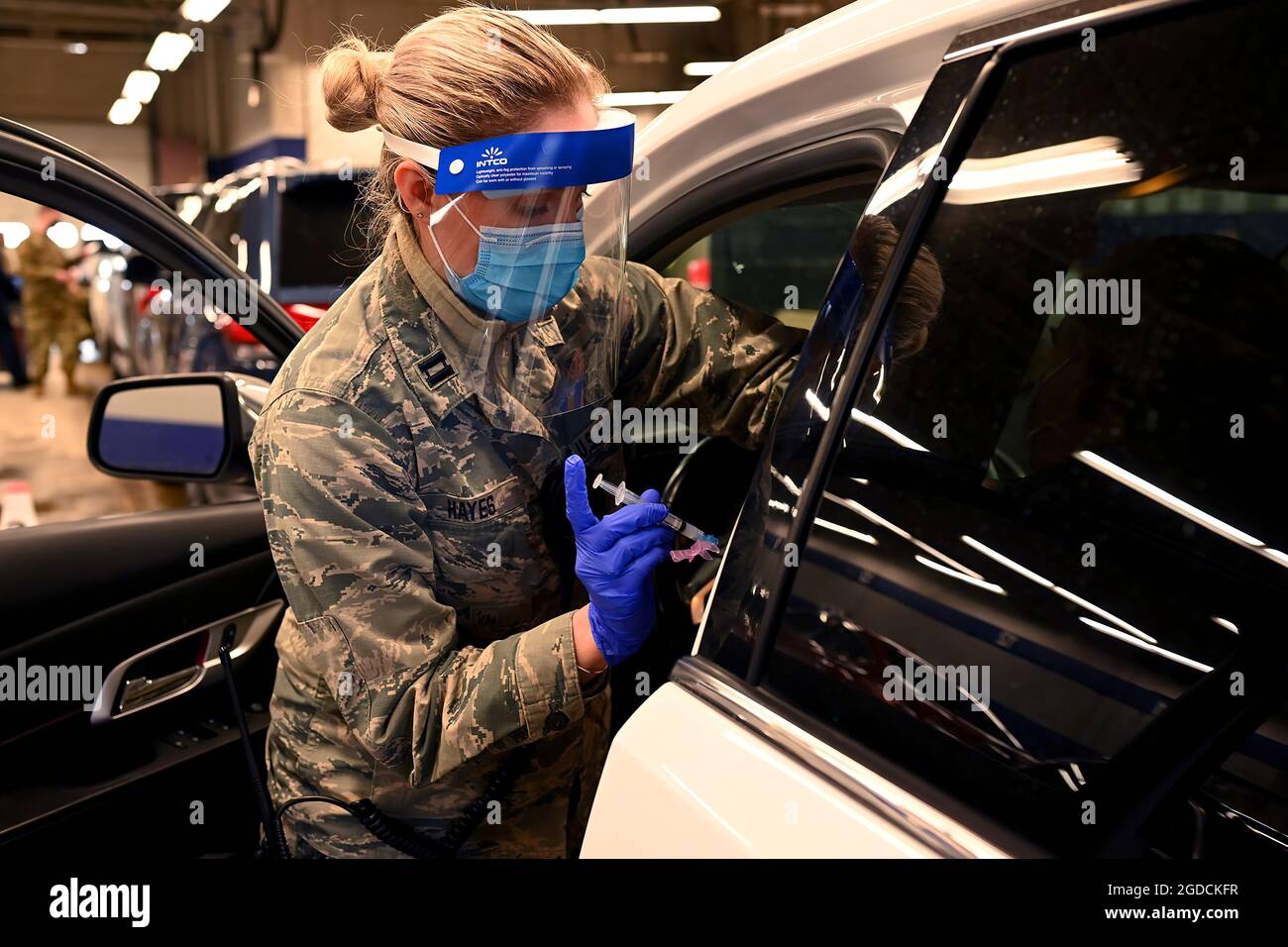 Capt. Alexa Hayes of the 157th Medical Group, 157th Air Refueling Wing, NHANG, administers a Moderna vaccine Feb. 11, 2021 in Concord, N.H. Guardsmen administer hundreds of tests and vaccinations each day at a former Sears Auto Center.  (U.S. Air National Guard photo by Staff Sgt. Charles Johnston) Stock Photo