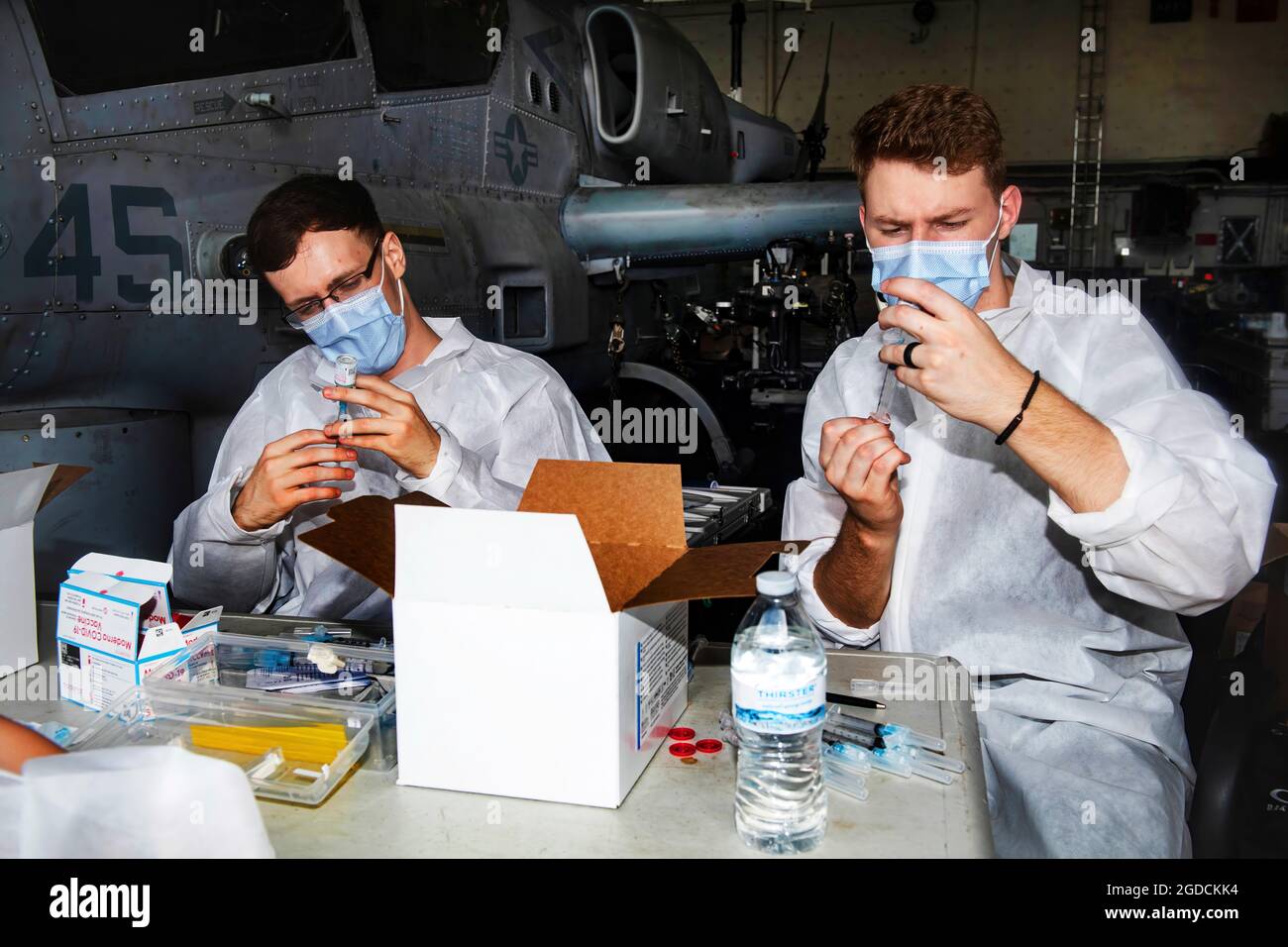 OKINAWA, Japan (Feb. 14, 2021) Hospital Corpsmen Dillon Bothell, left and Devin Declercq prepare COVID-19 vaccination shots aboard amphibious transport dock ship USS New Orleans (LPD 18). New Orleans, part of the America Expeditionary Strike Group, along with the 31st Marine Expeditionary Unit, is operating in the U.S. 7th Fleet area of responsibility to enhance interoperability with allies and partners and serve as a ready response force to defend peace and stability in the Indo-Pacific region. (U.S. Navy photo by Mass Communication Specialist 2nd Class Kelby Sanders) Stock Photo