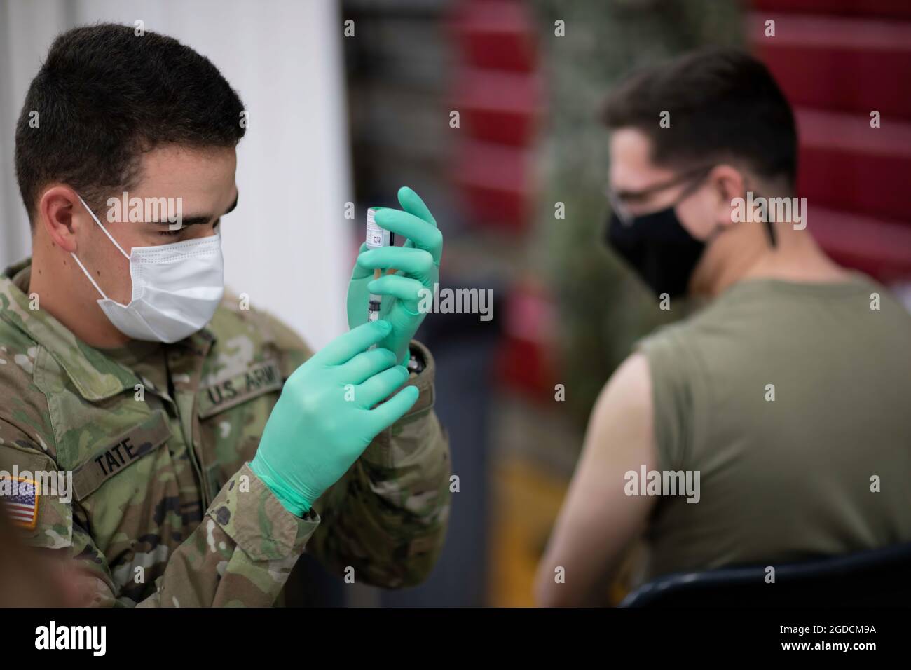 U.S. Army Pfc. Tanner Tate, assigned to the 627th Hospital Center out of Fort Carson, Colo., prepares to administer a COVID vaccine to a fellow Soldier at a state-run, federally-supported Community Vaccination Center in Elizabeth, N.J.. U.S. Northern Command, through U.S. Army North, remains committed to providing continued, flexible Department of Defense support to the Federal Emergency Management Agency as part of the whole-of-government response to COVID-19. (U.S. Navy photo by Chief Mass Communication Specialist Barry Riley) Stock Photo