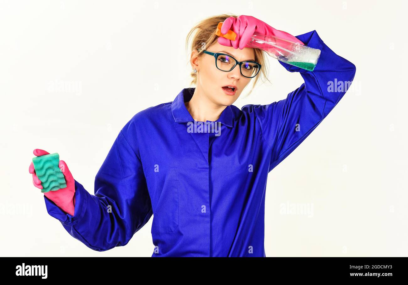 Tired woman in gloves with spray and sponge cleaning house. Housekeeper with cleaning tools. Household. Stock Photo