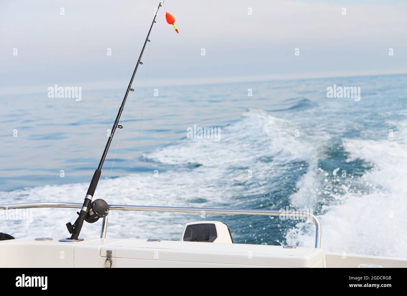 A rod with float bobber at the top in natural setting with sea on  background Stock Photo - Alamy