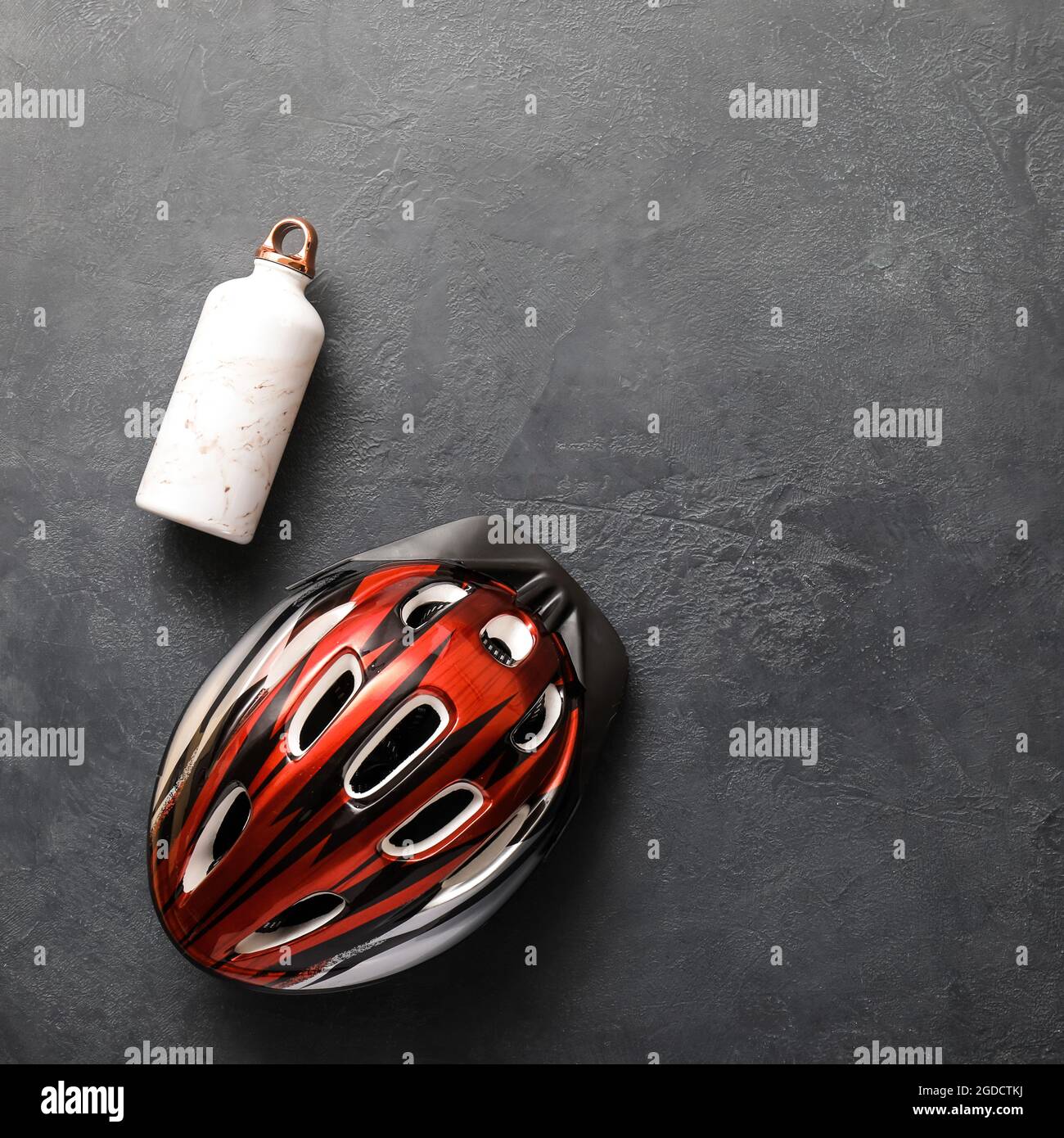 Bike helmet and bottle of water on dark background Stock Photo - Alamy