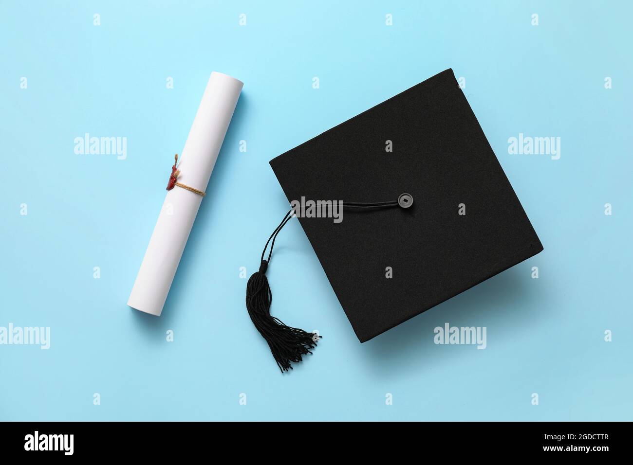 Graduation hat and diploma on color background Stock Photo - Alamy