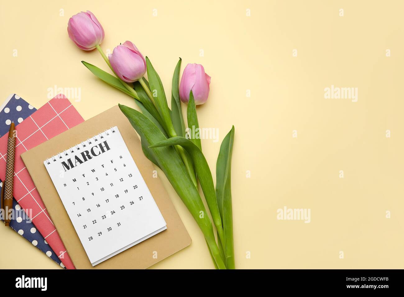 Calendar with flowers and notebooks on color background Stock Photo - Alamy