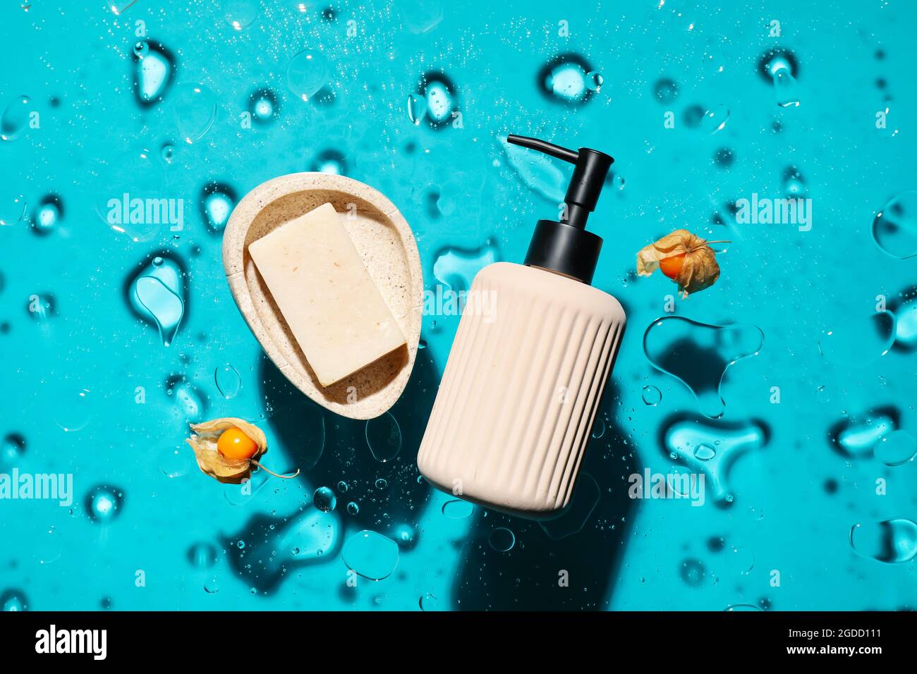 Bottle of cosmetic product, soap and berries in water on color background Stock Photo