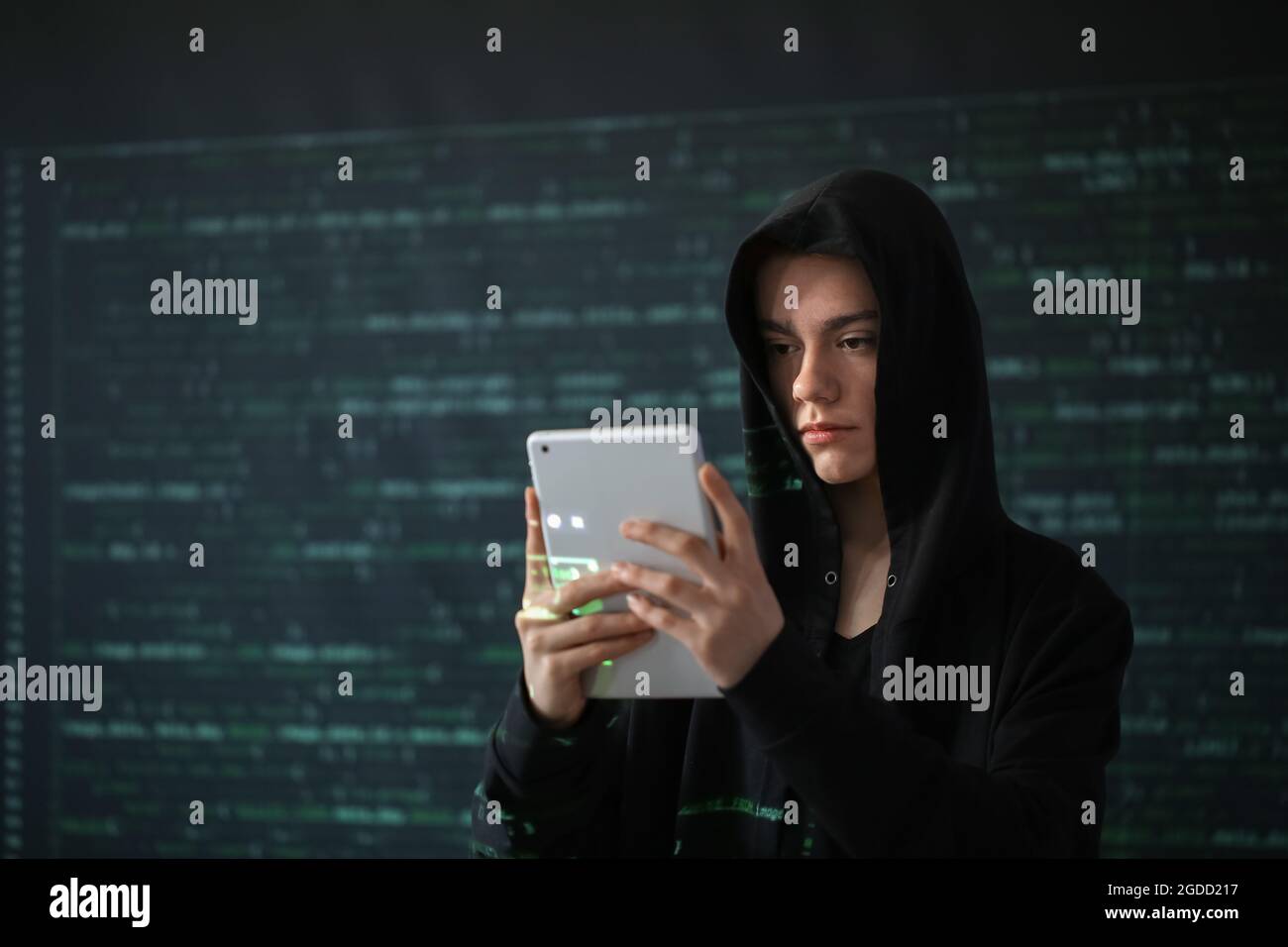 Hacker with tablet computer on dark background Stock Photo