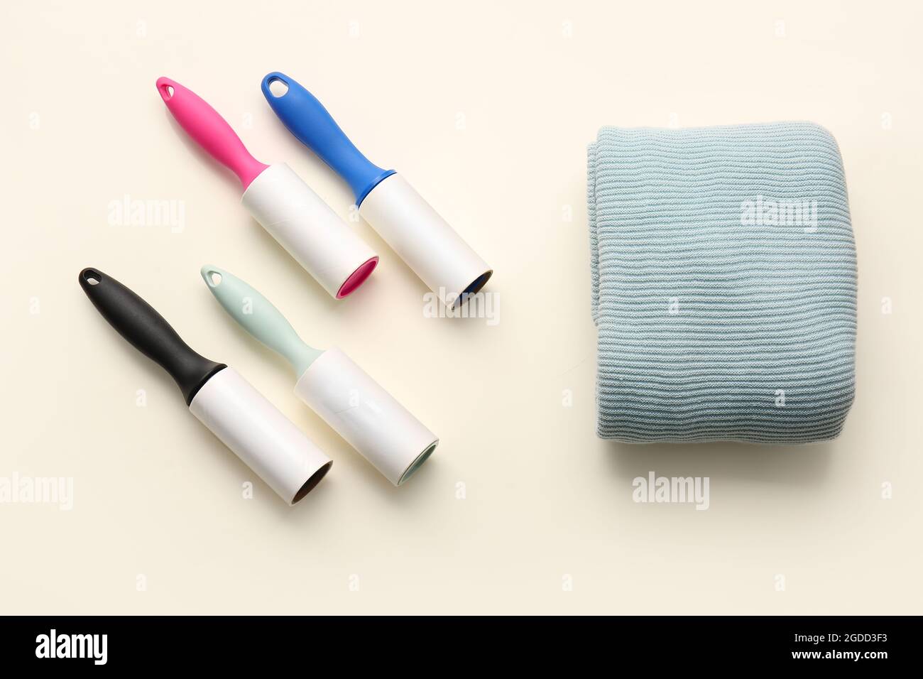 Lint rollers and clothes on color background Stock Photo