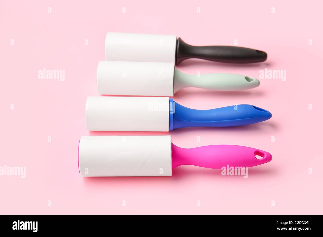 Different lint rollers on color background Stock Photo