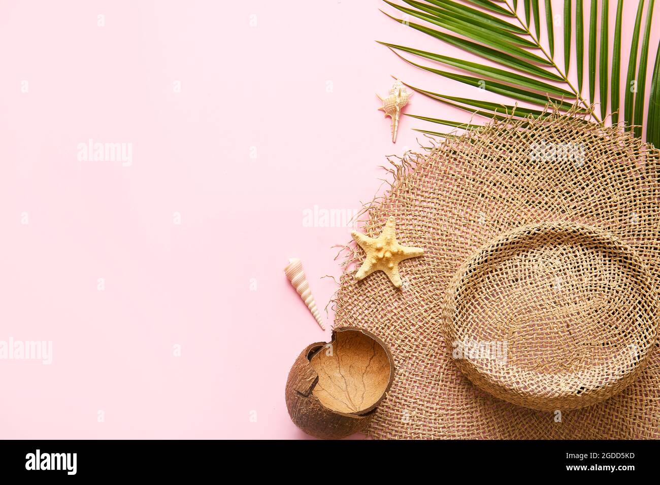 Composition with straw hat, coconut shell and palm leaf on color ...