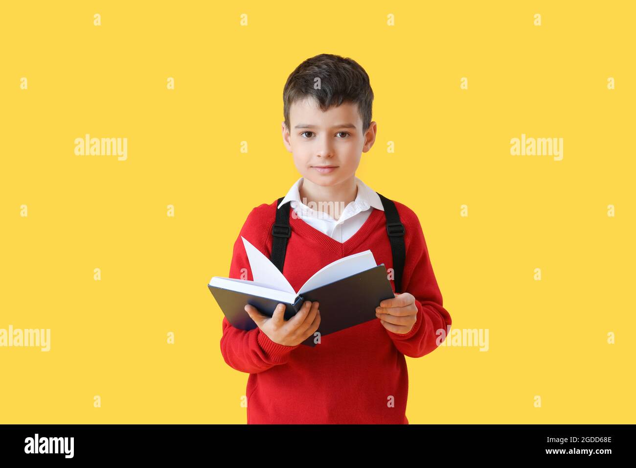 Little schoolboy reading book on color background Stock Photo - Alamy