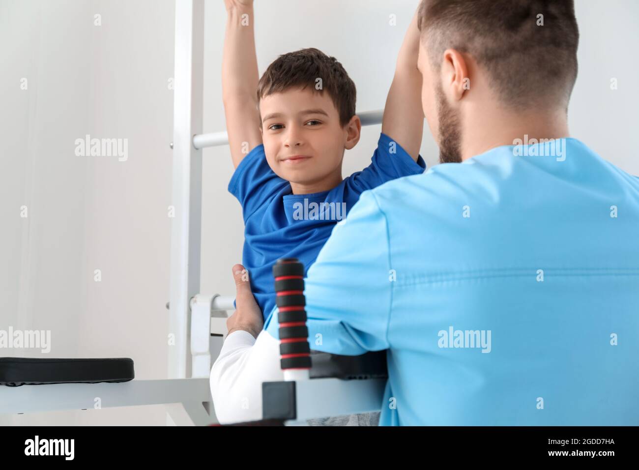 Physiotherapist working with boy in rehabilitation center Stock Photo