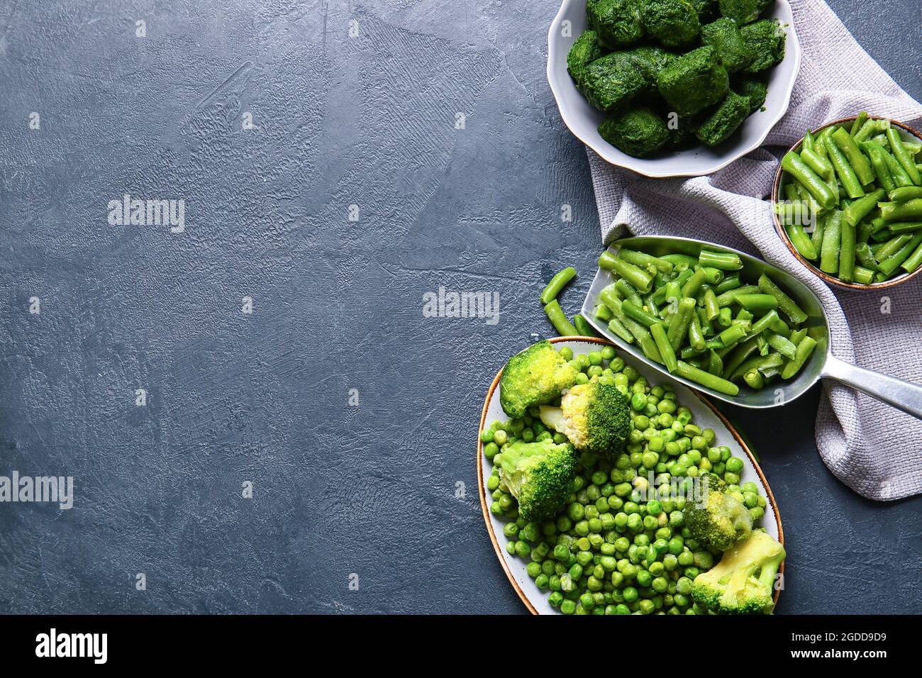 Composition with frozen green vegetables on dark background Stock Photo