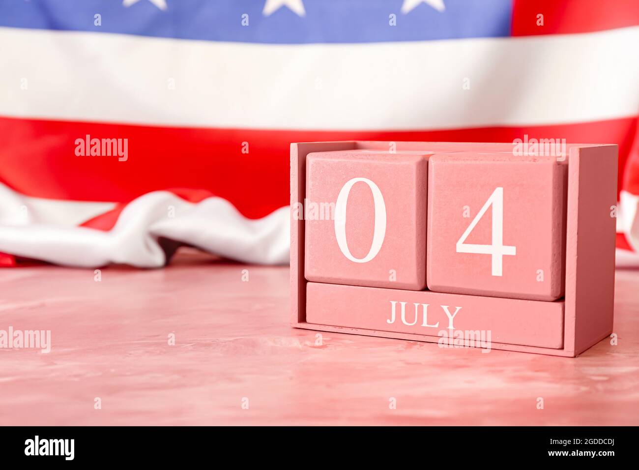 Calendar with date of Independence Day on table against American flag ...