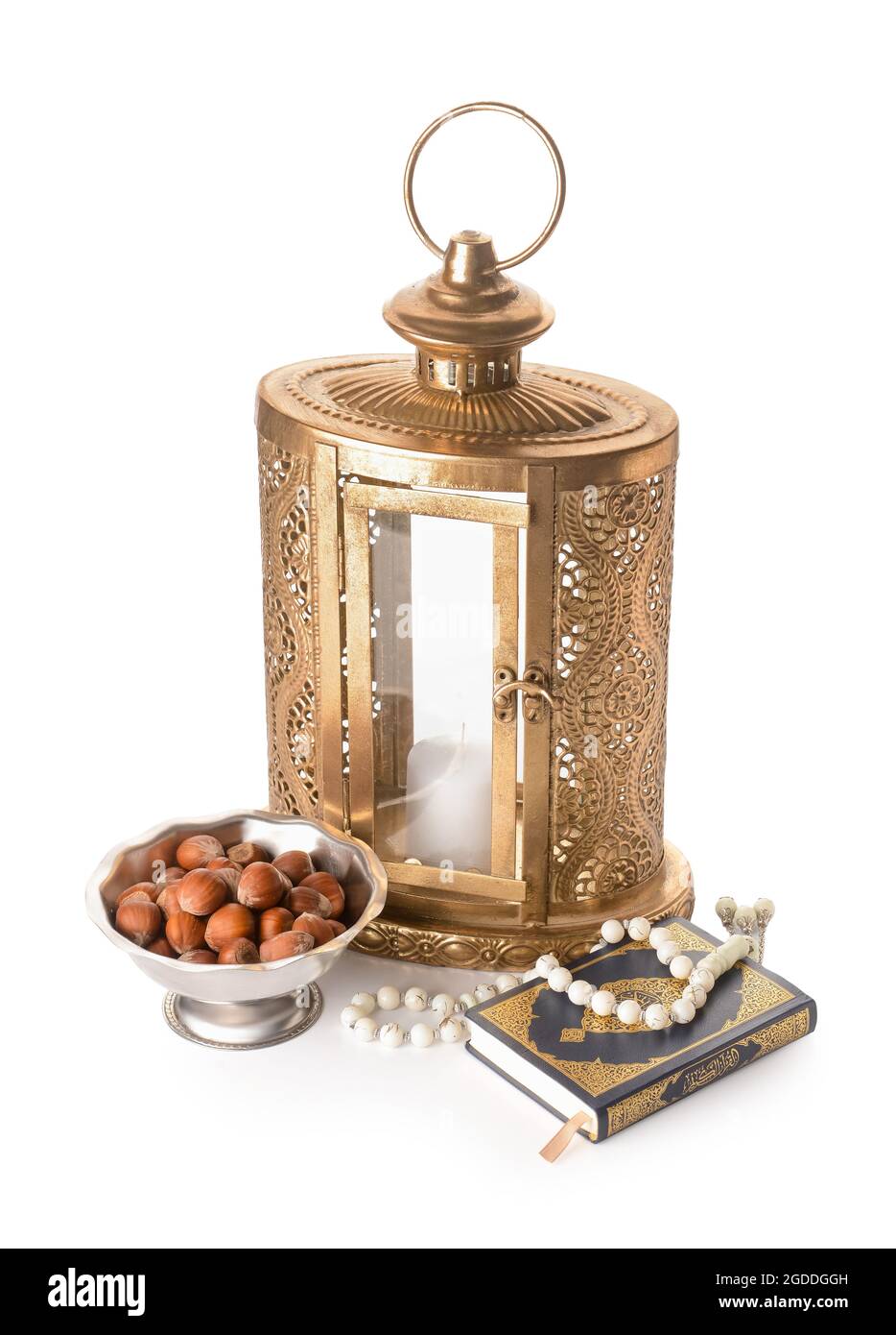 Muslim lantern with Quran, tasbih and nuts on white background Stock Photo