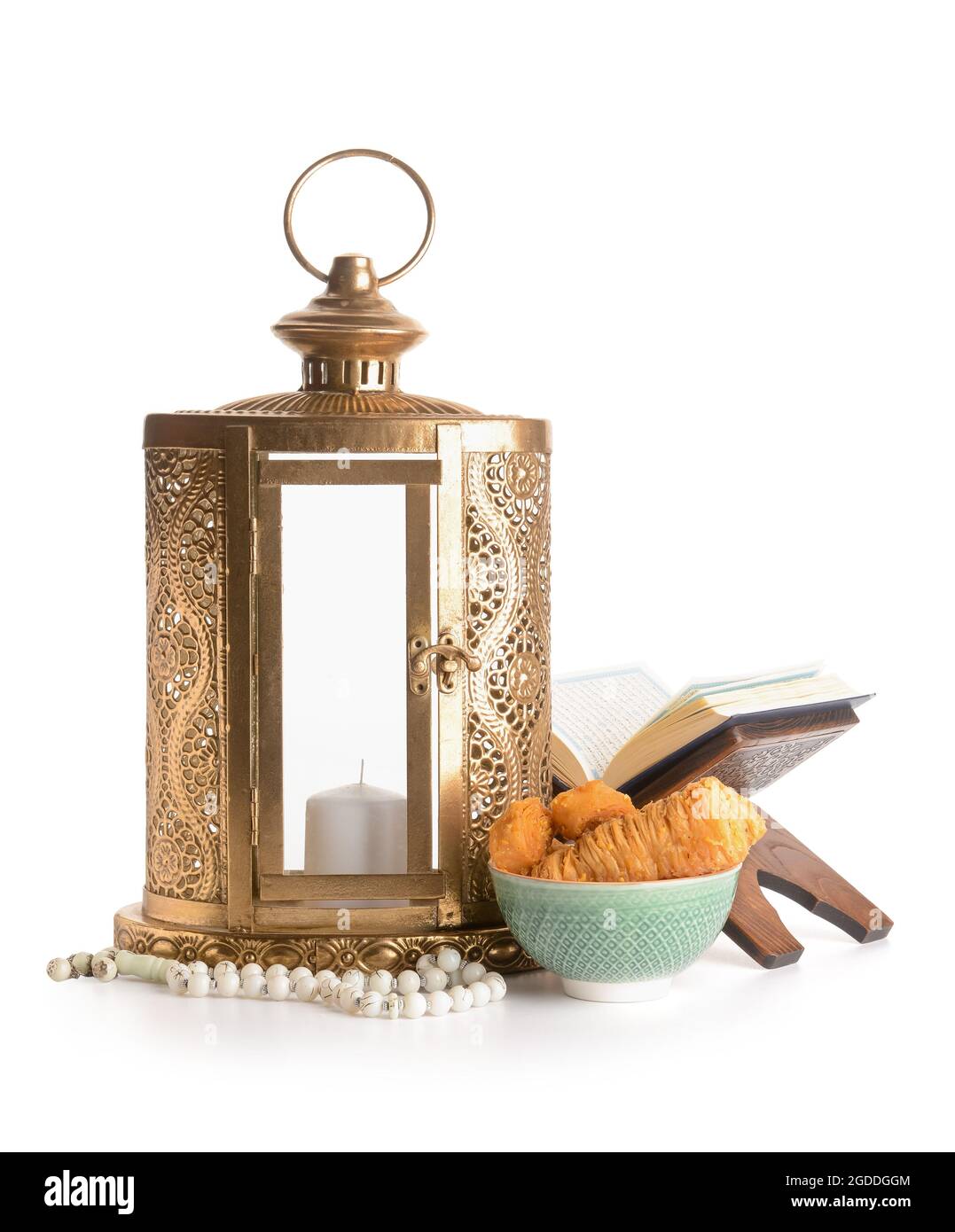 Muslim lantern with Quran, tasbih and Turkish sweets on white background Stock Photo