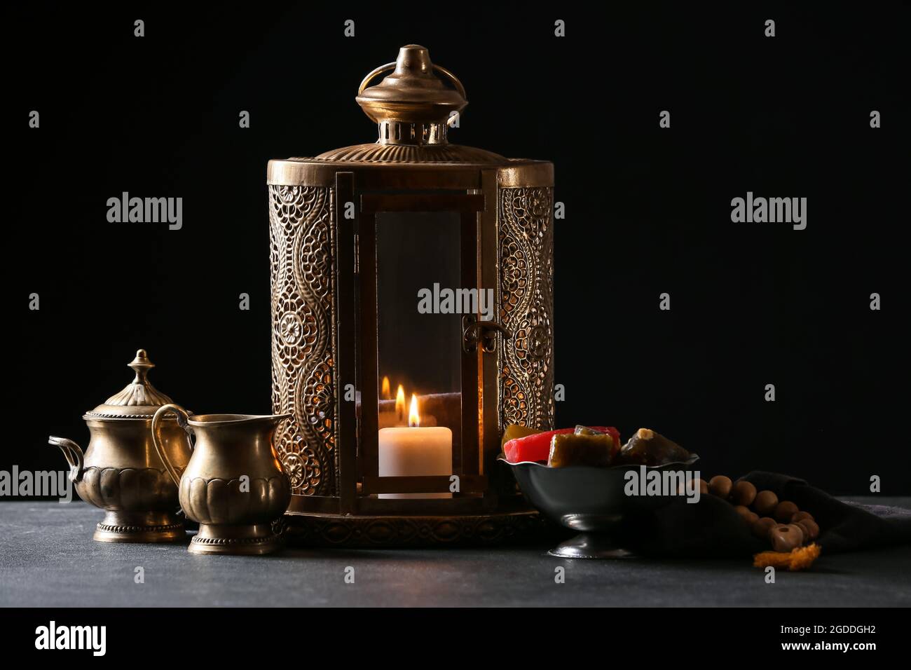 Muslim lantern with Turkish sweets on dark background Stock Photo