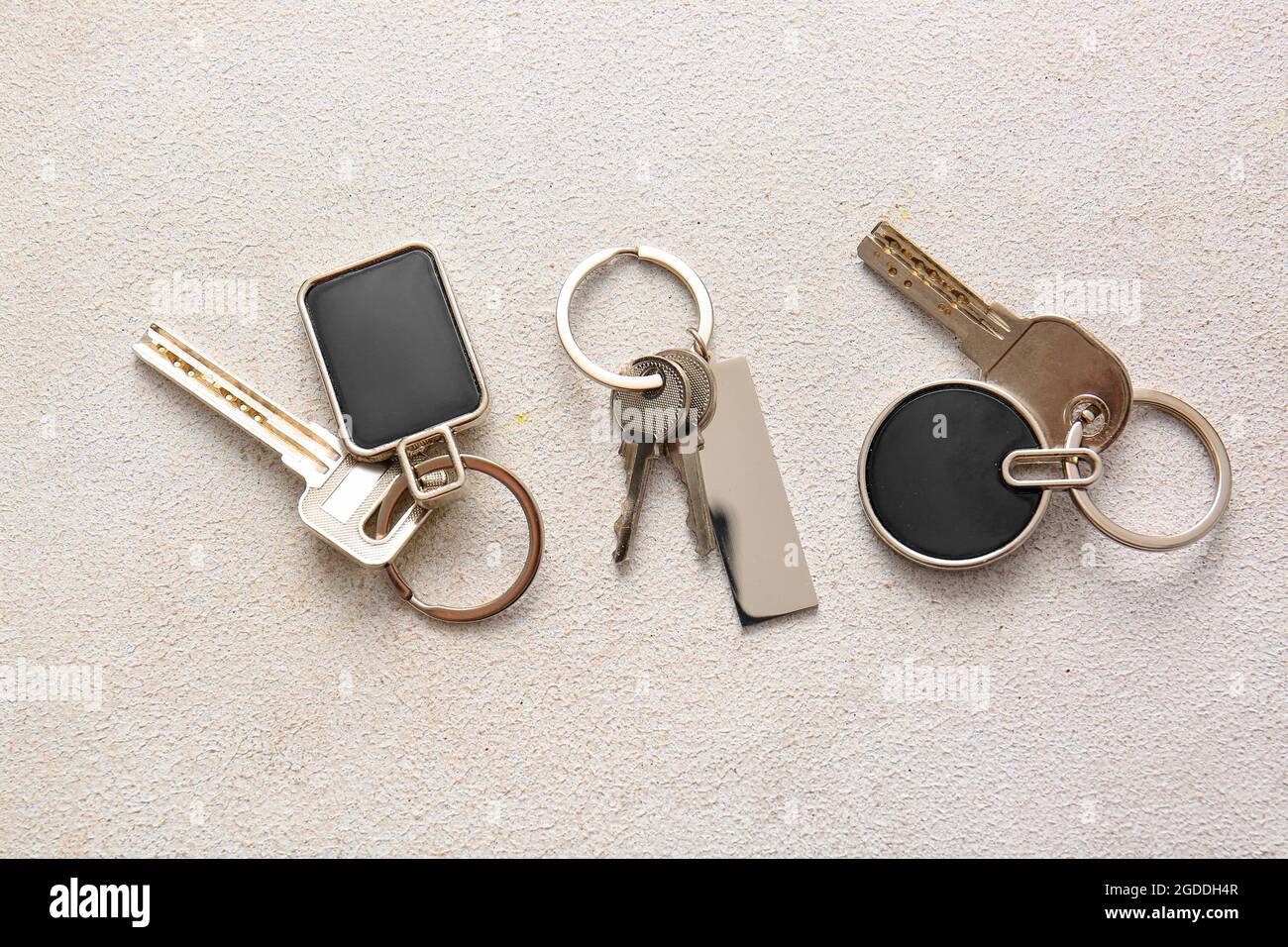 Keys with stylish keychains on light background Stock Photo