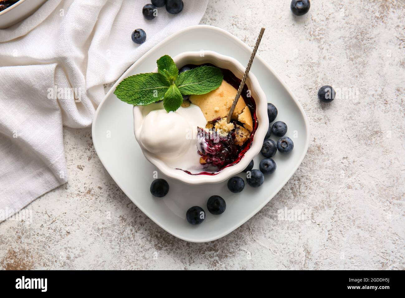 Ramekin with blueberry cobbler and ice cream on light background Stock