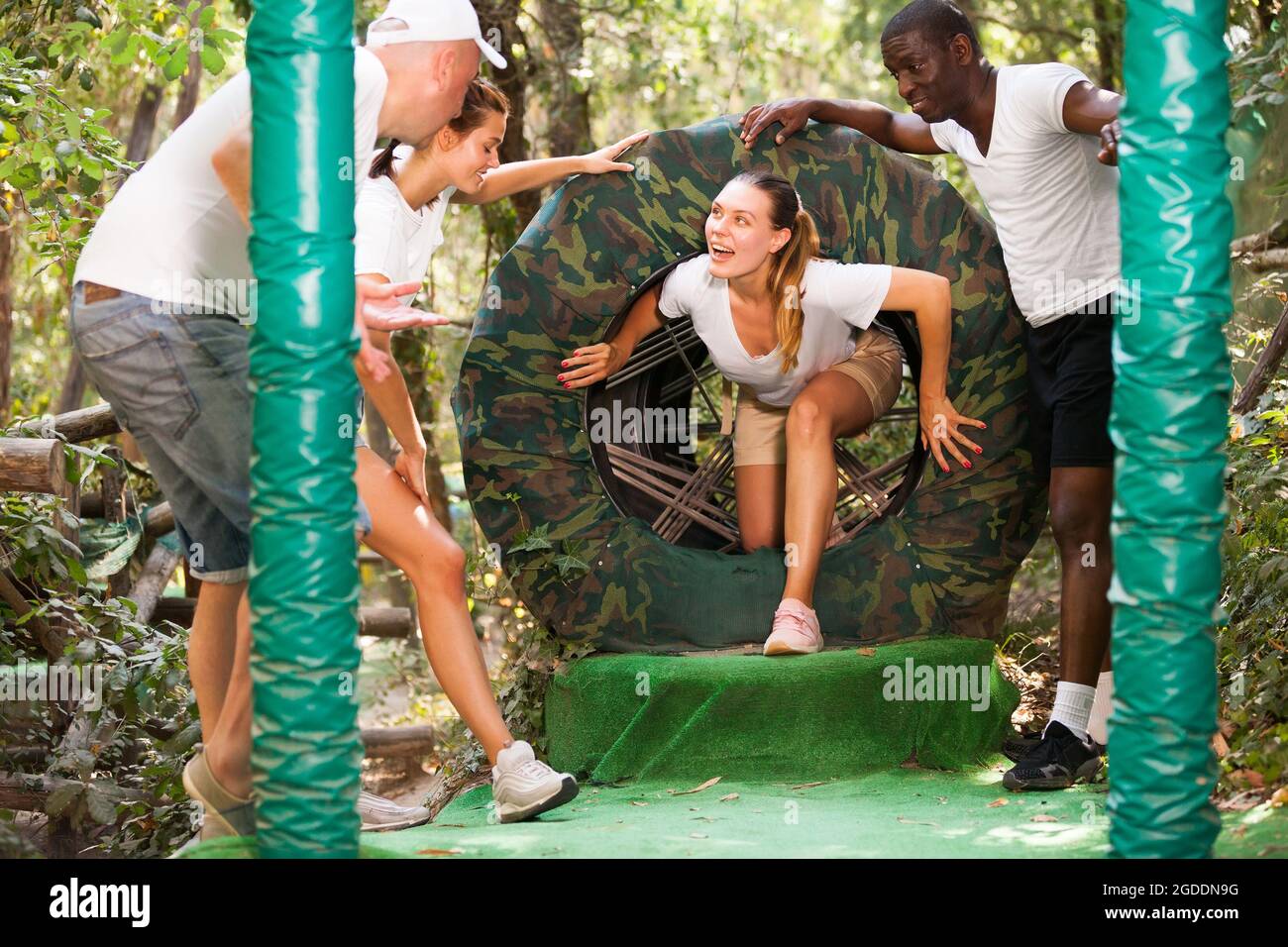 Friends passing obstacles at adventure park Stock Photo - Alamy