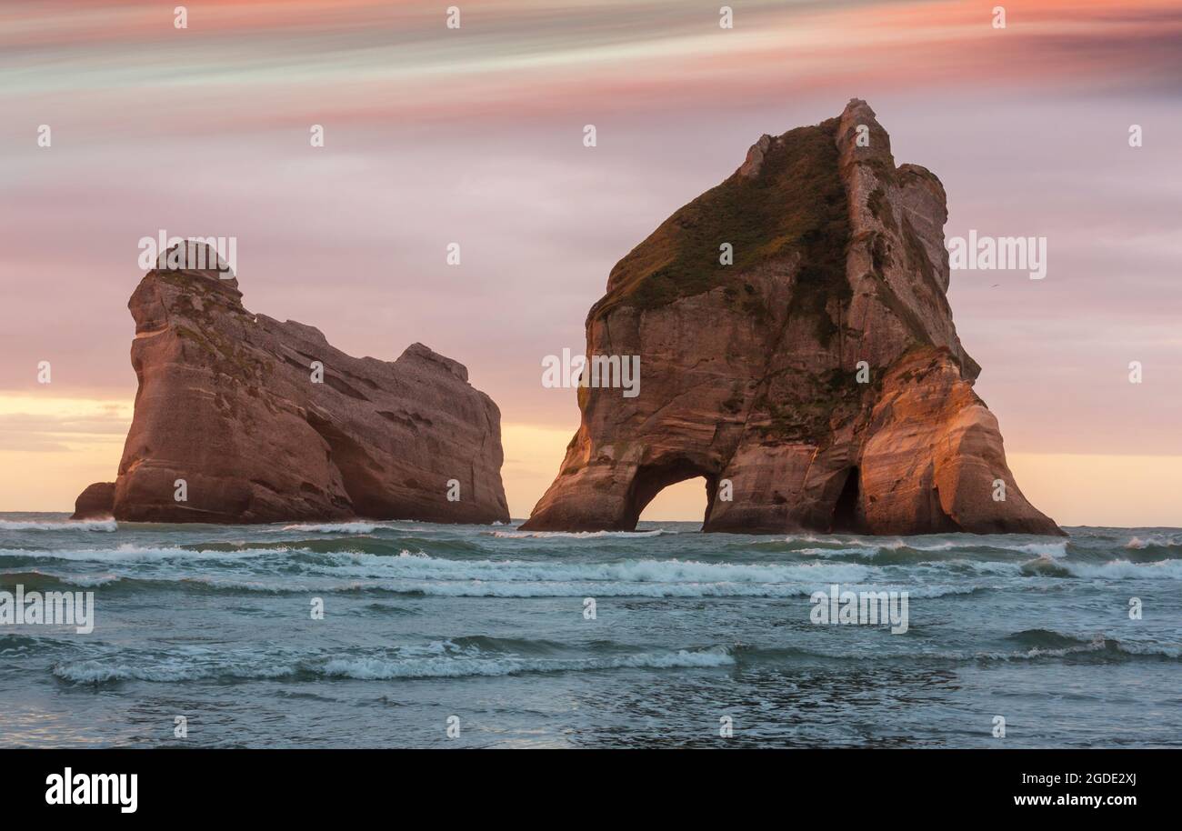 The Archway Islands of Wharariki Beach at sunset in New Zealand Stock Photo