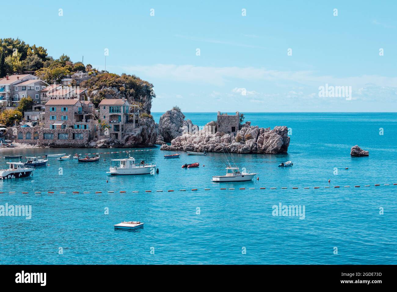A picturesque sea bay among the mountains and rocks on the Adriatic sea coast. Mediterranean seascape with houses tiled roofs and boats on bay Stock Photo
