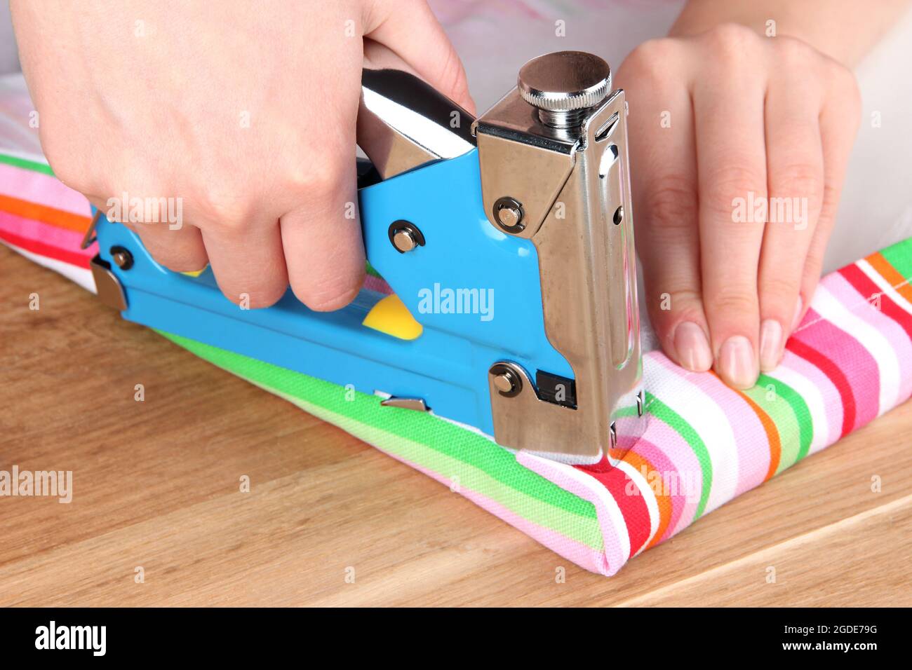 Fastening fabric and board using construction stapler Stock Photo Alamy