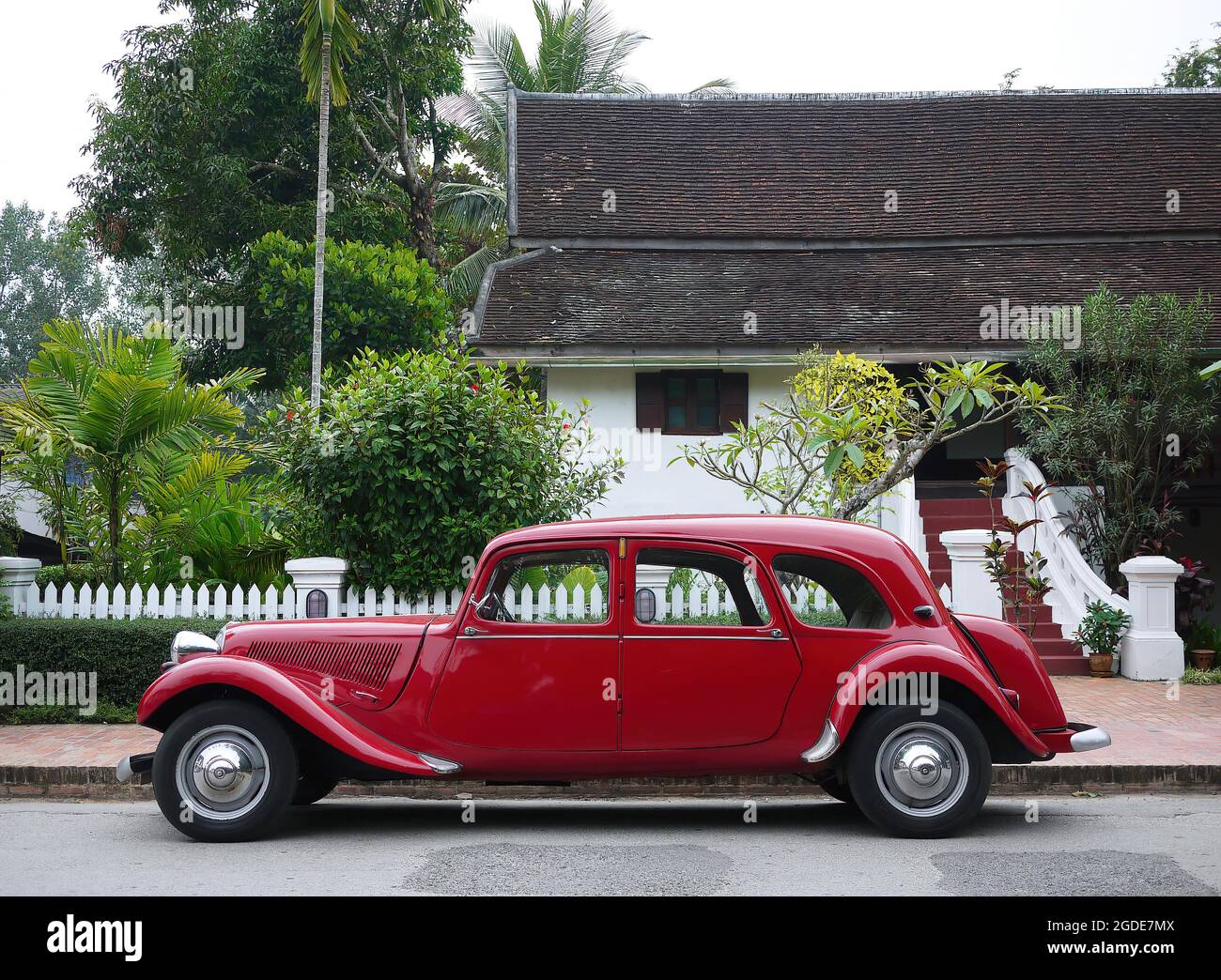 Classic red Citroen Traction Avant vintage car side view against 