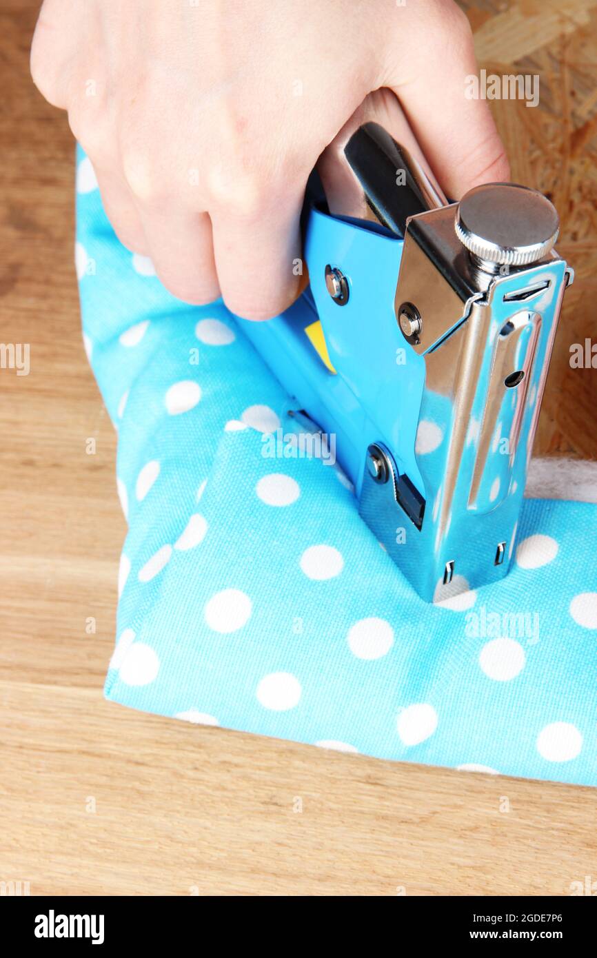 Fastening fabric and board using construction stapler Stock Photo Alamy