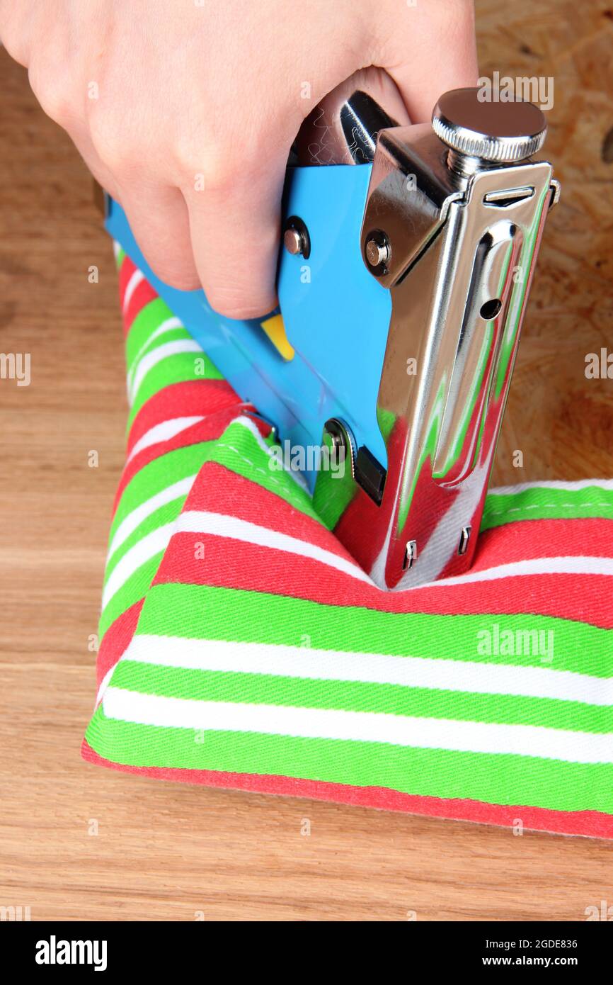 Fastening fabric and board using construction stapler Stock Photo Alamy