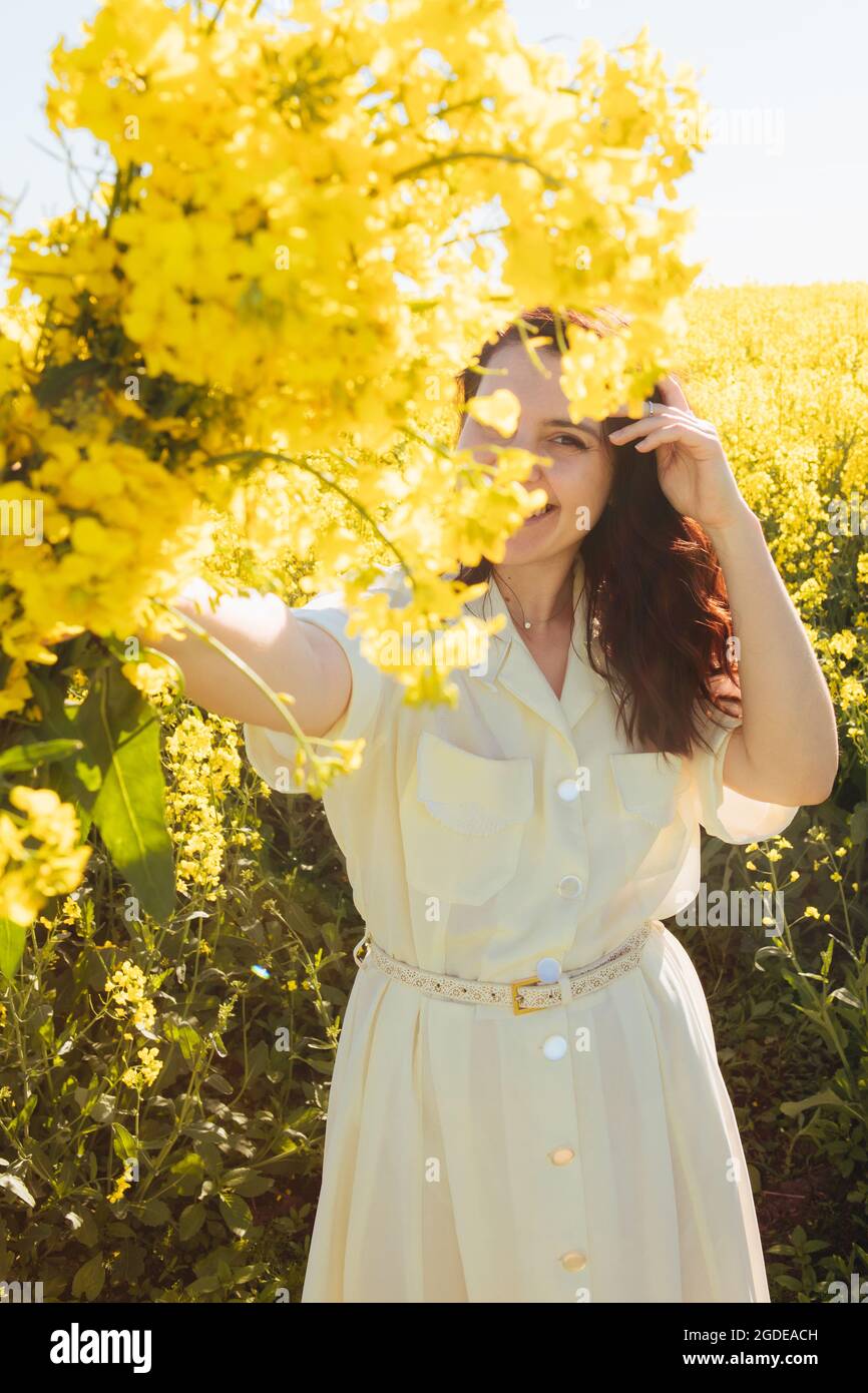 beautiful woman standing in rapeseed field summertime Stock Photo - Alamy