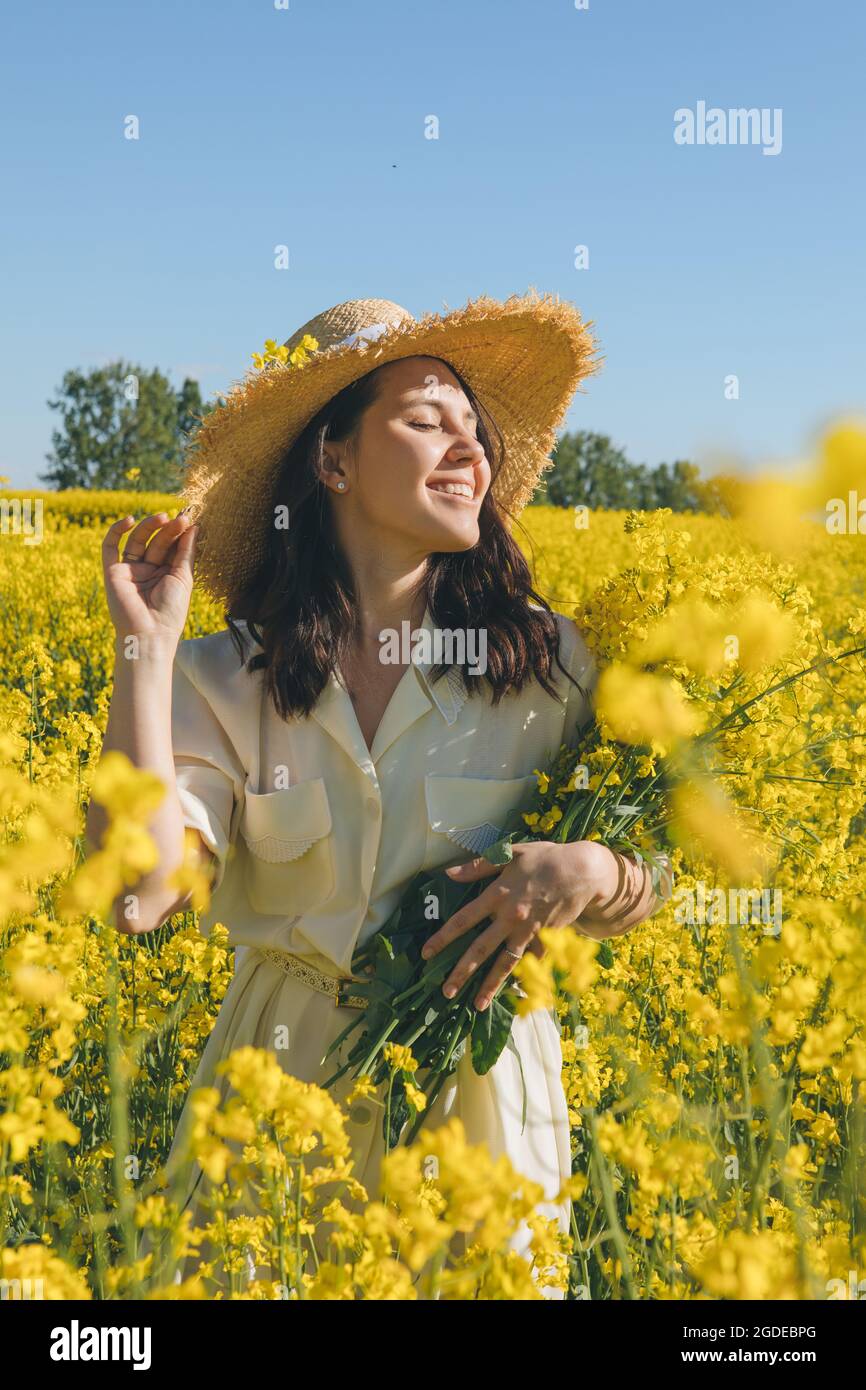 beautiful woman standing in rapeseed field summertime Stock Photo - Alamy
