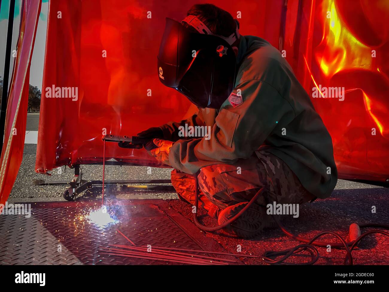 U.S. Air Force Airman 1st Class Mason Hughes, 633rd Civil Engineer Squadron structural journeyman, welds a pit plate closed at Joint Base Langley-Eustis, Va., Dec. 4, 2019. Pit plates are covers that protect water valves around the installation and are welded down for safety. (U.S. Air Force photo by Tech. Sgt. Carlin Leslie) Stock Photo