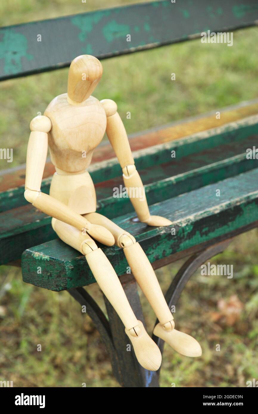 Wooden pose puppet sitting on bench outdoors Stock Photo Alamy