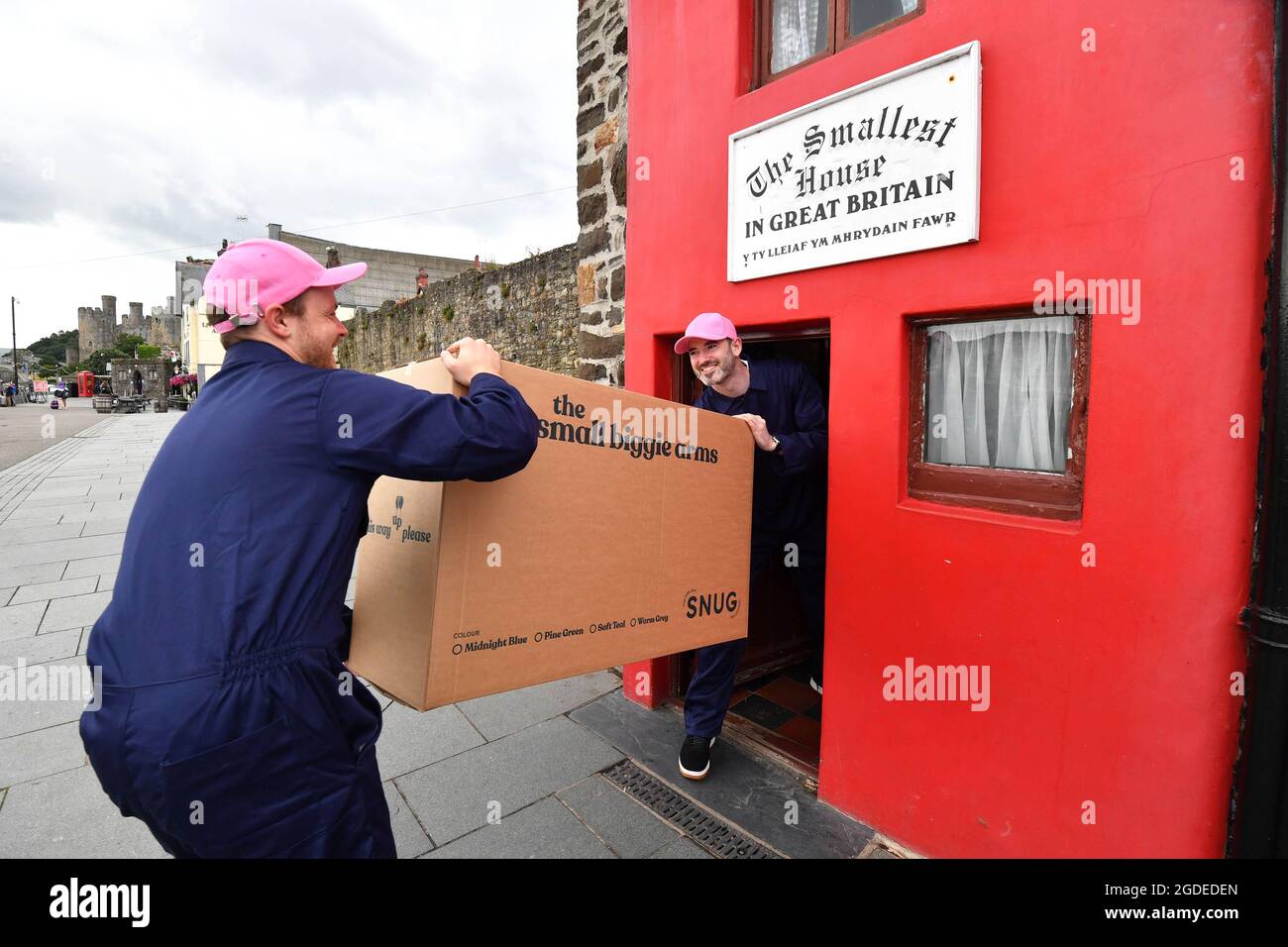 EDITORIAL USE ONLY Dave and Steve deliver one of Snug's new 'Small Biggie' sofas to The Smallest House in Great Britain, in Conwy, North Wales to demonstrate the 'sofa in a box's ability to fit the most awkward of spaces. Picture date: Friday August 13, 2021. Stock Photo