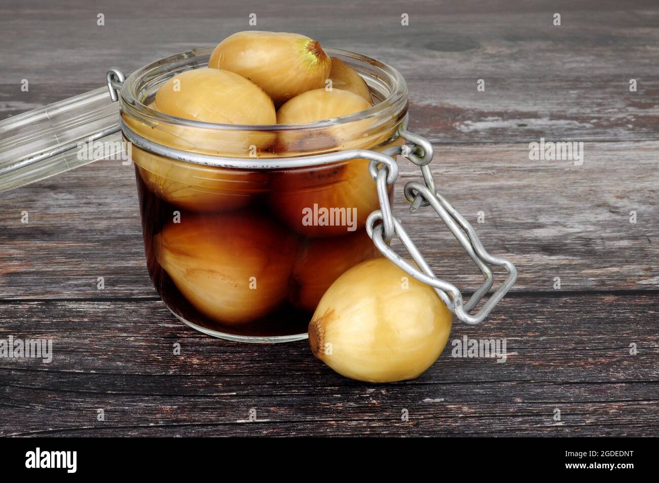 Glass storage jar filled with pickled onions in malt vinegar on a