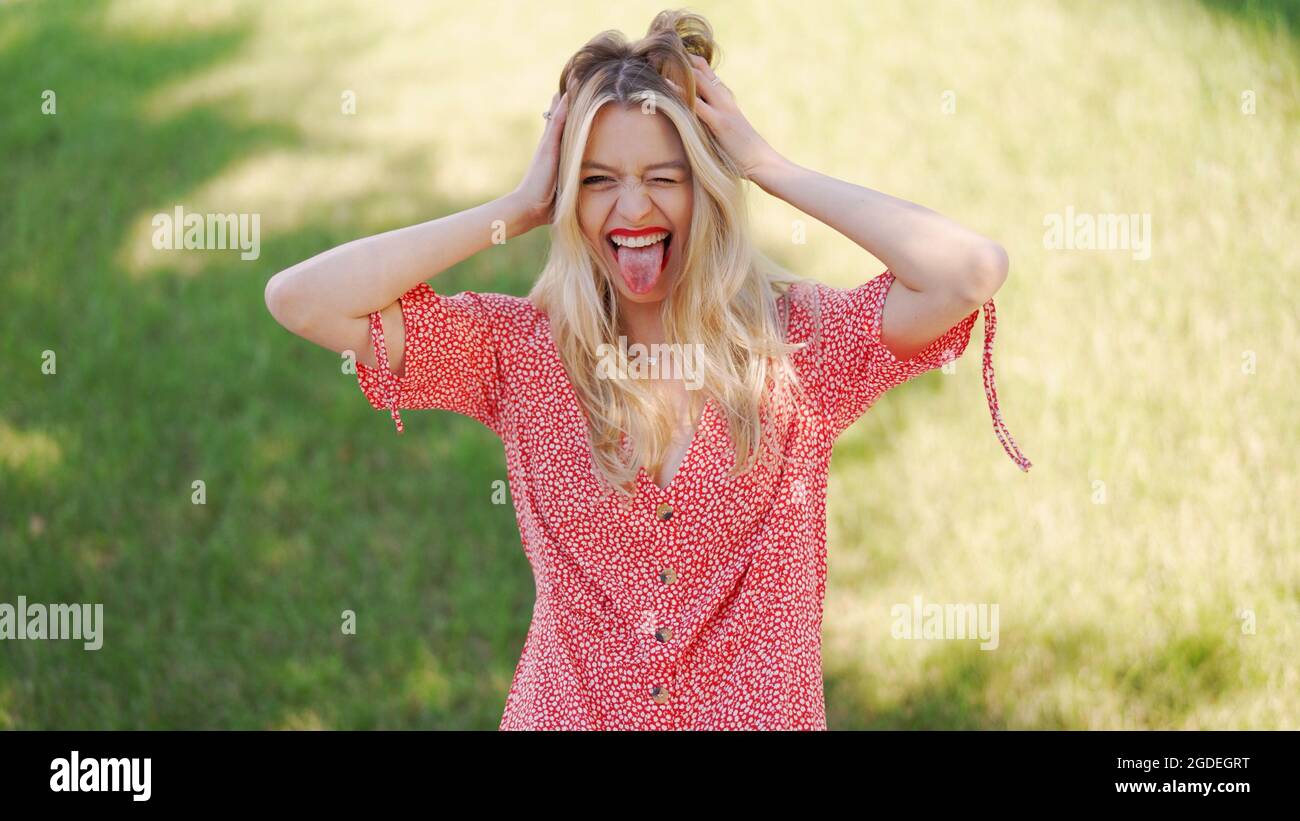 Stylish female making face in park Stock Photo