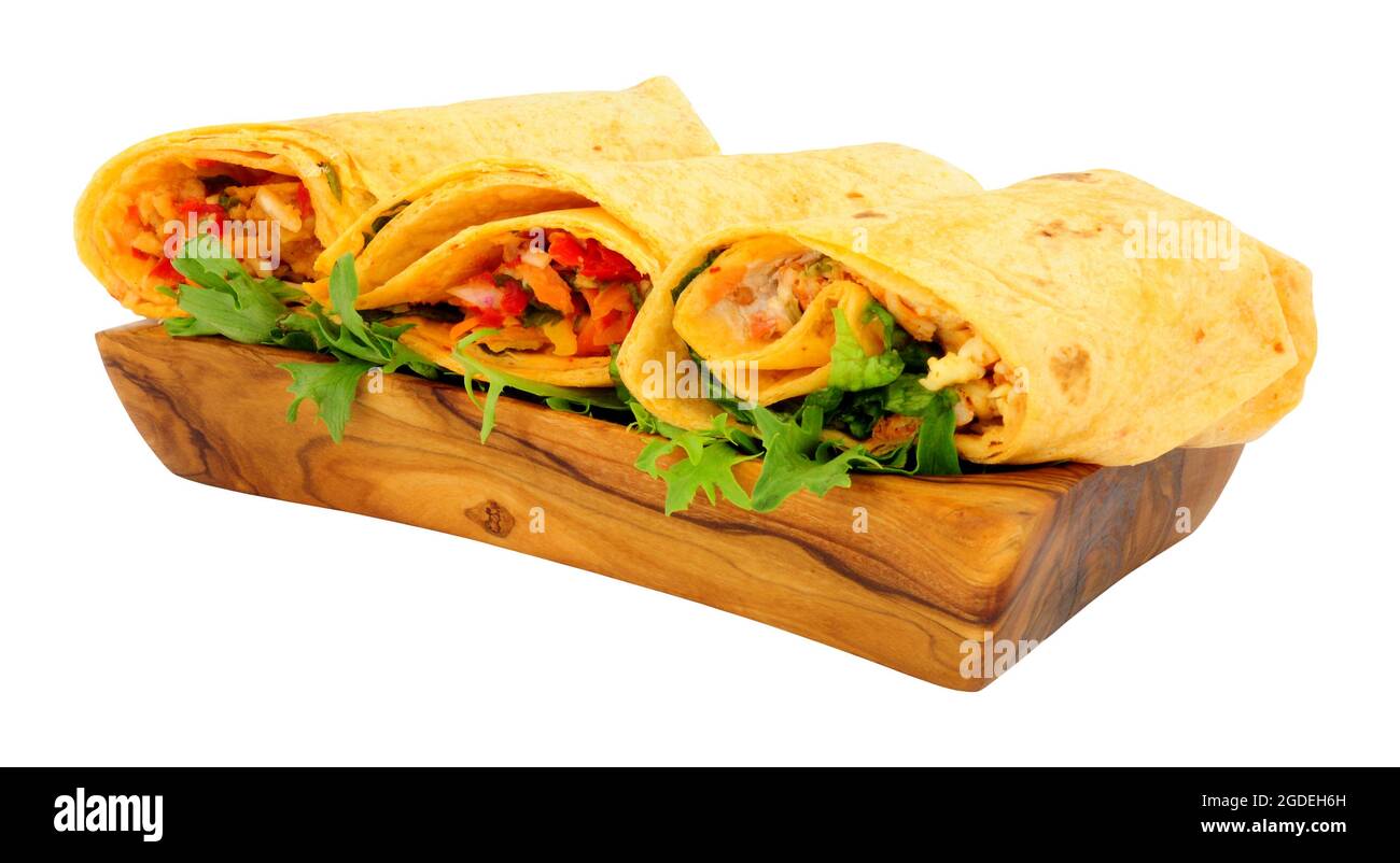 Group of filled soft tortilla wraps in a olive wood serving bowl isolated on a white background Stock Photo