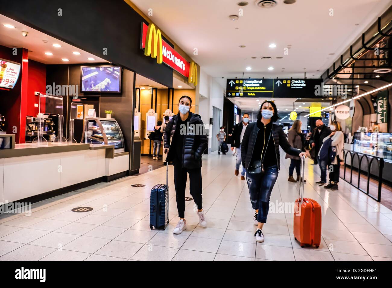 Melbourne, Australia. 11th May, 2021. Passengers with suitcases walk through a food court at
