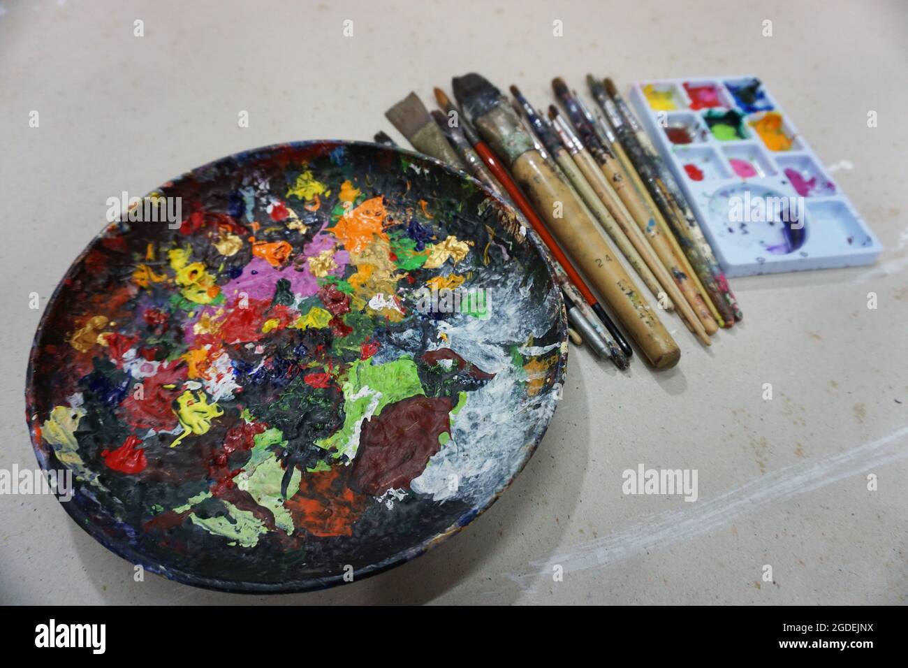 art school supplies Paintbrushes of various sizes, color palettes, acrylic paints , mixing palette Stock Photo